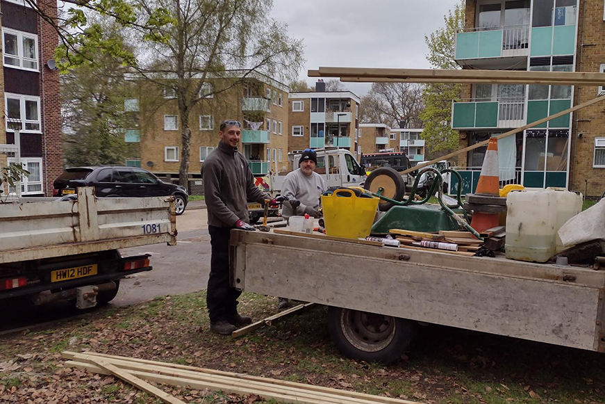 Two men with some tools and a truck