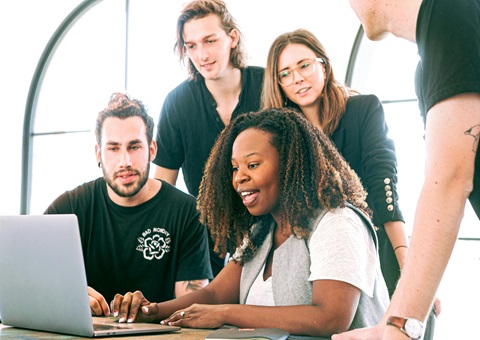 Young colleagues gathered around a laptop