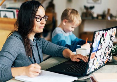 Woman at laptop, next to child