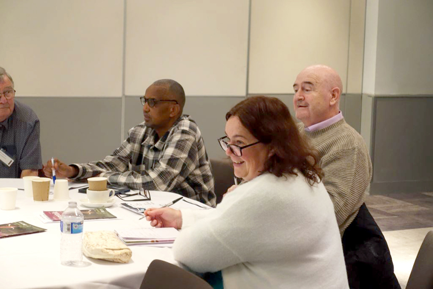 Several people taking notes at a table