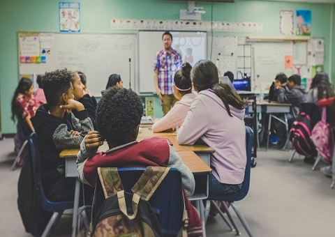 A classroom with pupils looking at teacher