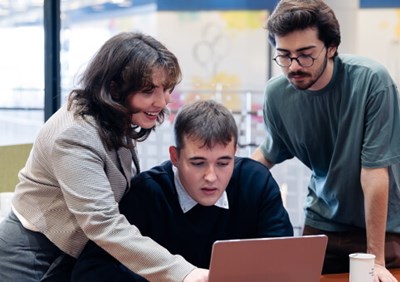 People gathered around laptop