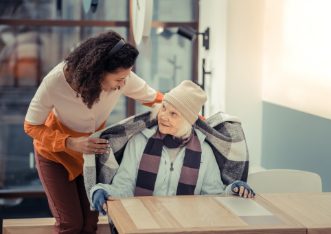 Someone giving a blanket to an elderly person