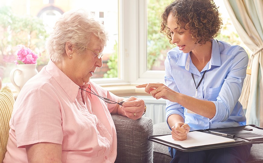 Two women discussing a Careline device