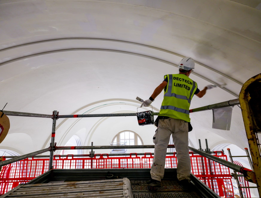 Decorator painting the art gallery ceiling