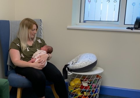 A mother in a chair holding her baby