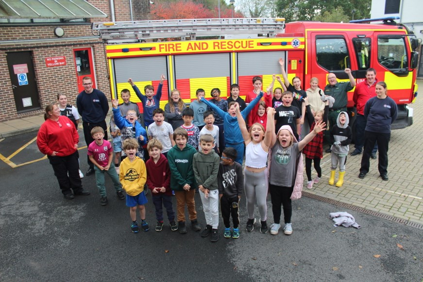 A group picture taken in front of a fire engine