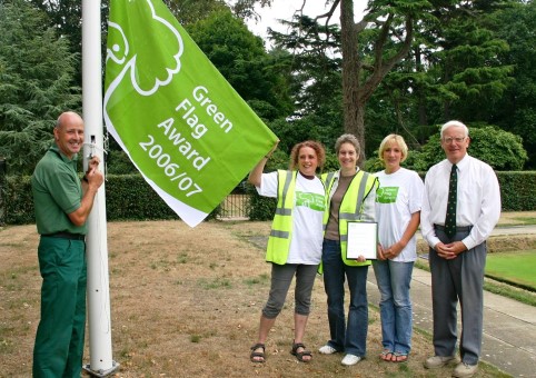 People hanging a Green Flag Award Flag