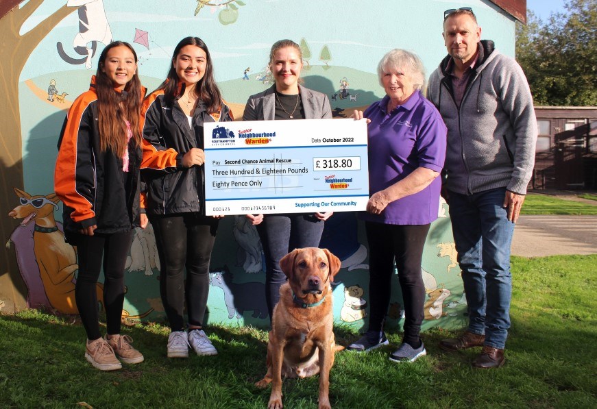 Group of people holding large cheque