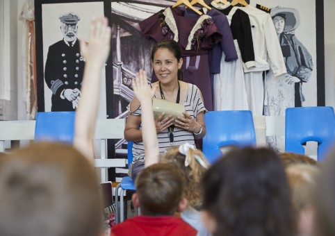 Children putting hands up at a learning activity