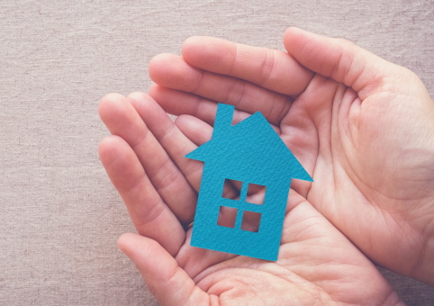 Hands holding a paper house