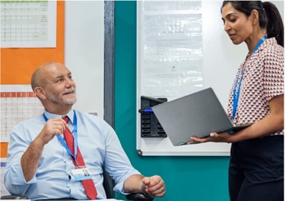 Woman with laptop and man in office