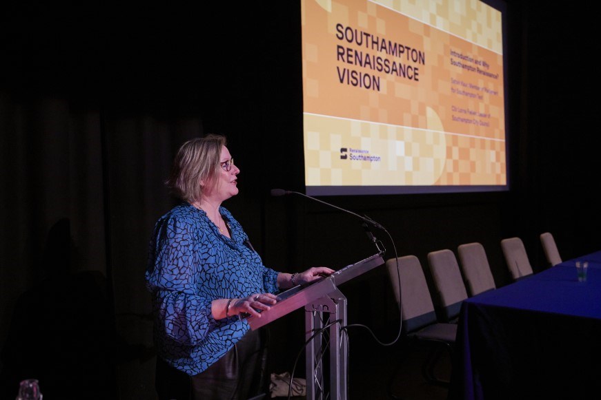 Leader at a podium in front of a presentation about Southampton Renaissance Vision