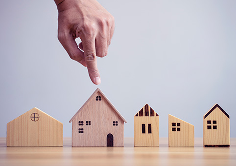 A collection of wooden buildings with a hand pointing at one