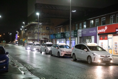 A row of taxis at night