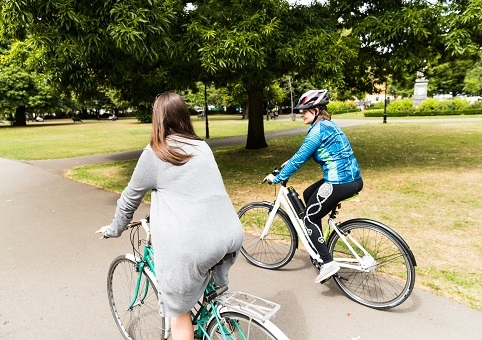 Two people cycling in a park