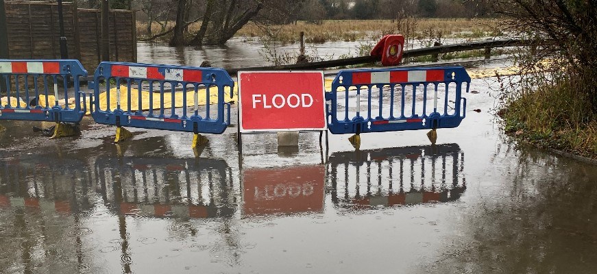 Flood warning sign and barricade in flood water