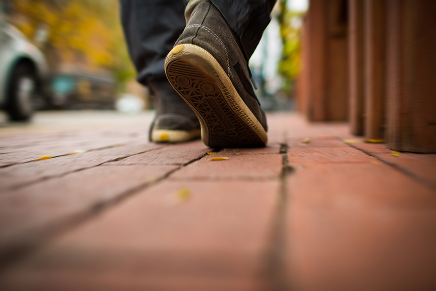 Close Up Of Person's Shoes Walking Down Street