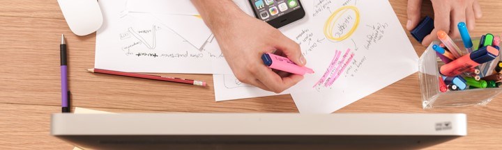 A person mapping out and highlighting plans on paper