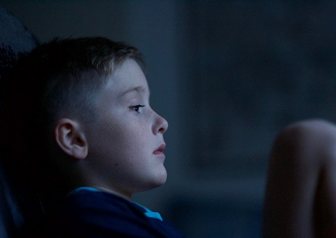 A boy sitting with head in his hands