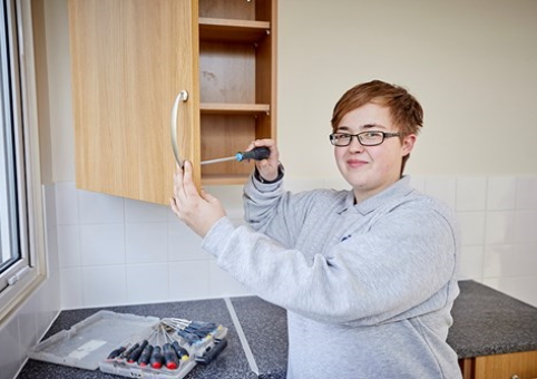 Someone fixing a cabinet