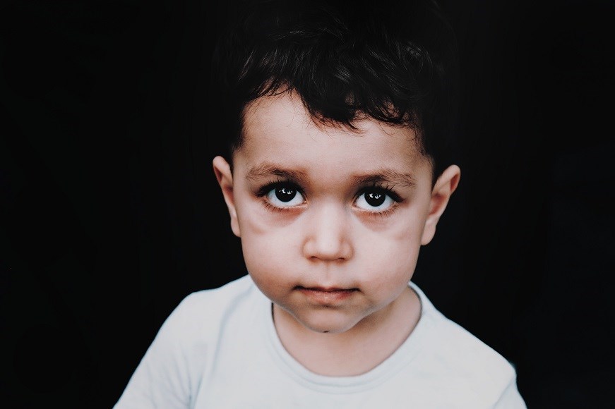 An infant boy in a white t shirt