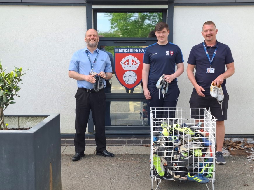Three Hampshire Football Association representatives alongside the association logo and donated football kit