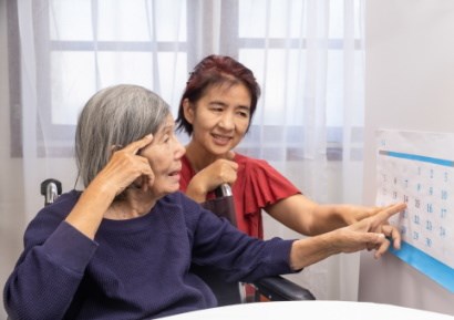 Carer helping elderly woman look at calendar