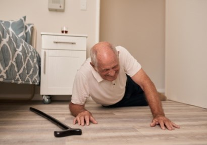 Man who has fallen on bedroom floor