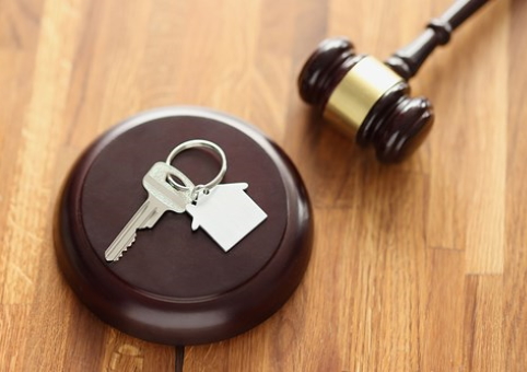 Gavel with keys and a house key chain on it