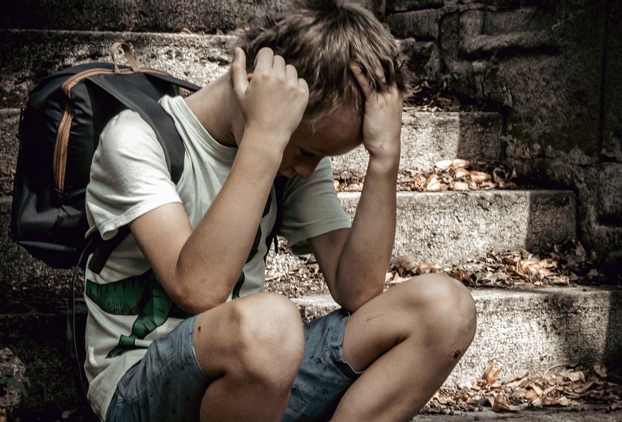 A boy sitting with head in his hands