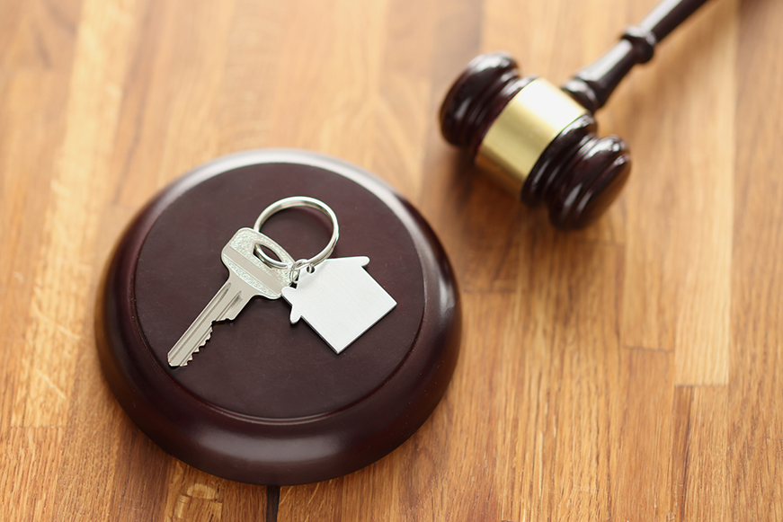 House keys on a block next to a gavel