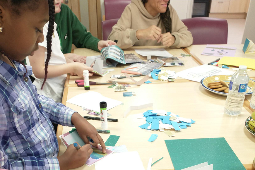 Several people of different ages and ethnicities doing arts and crafts at a table