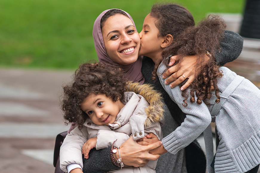 A woman and two children embracing