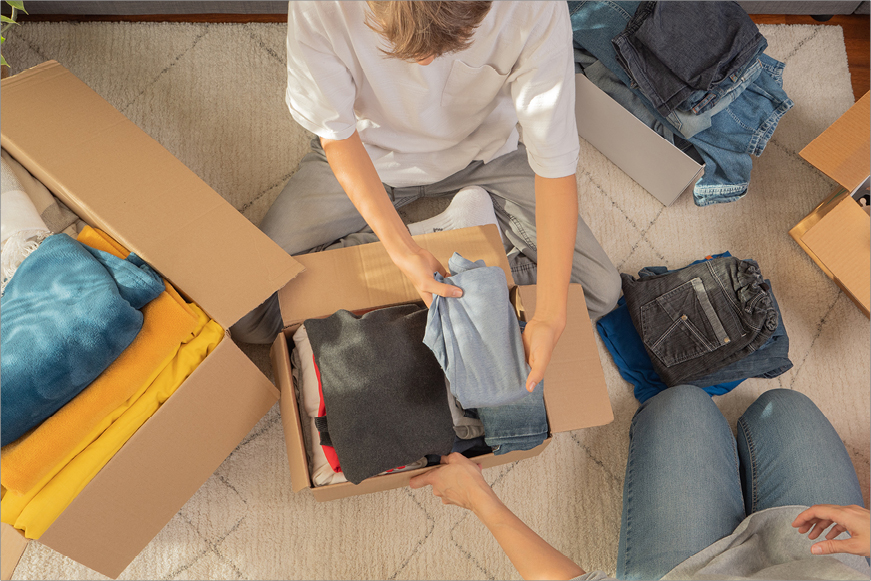 People packing clothing in boxes