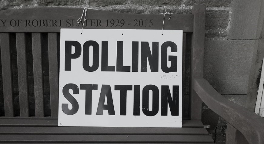 Polling station sign on a bench