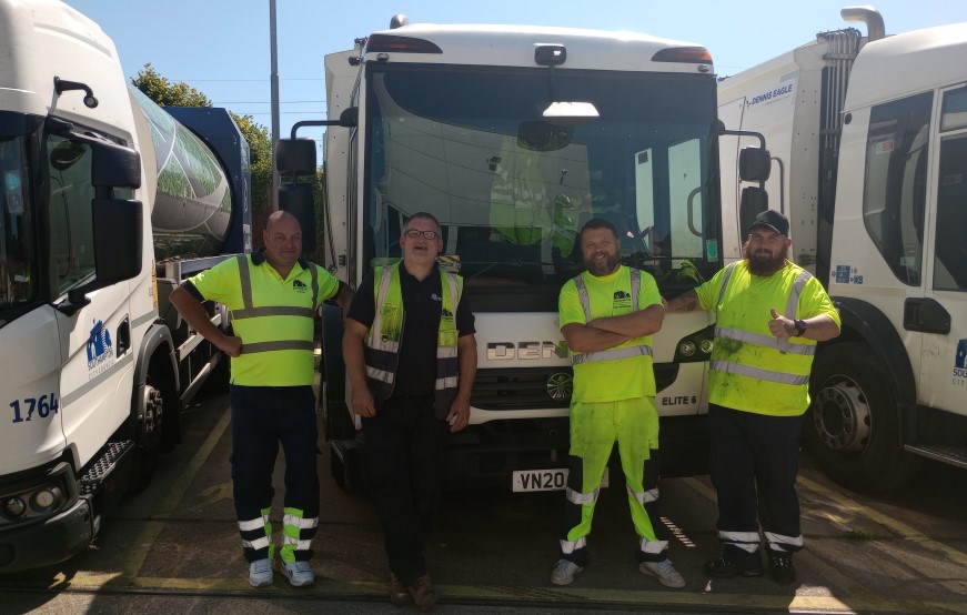 The crew next to their refuse vehicle