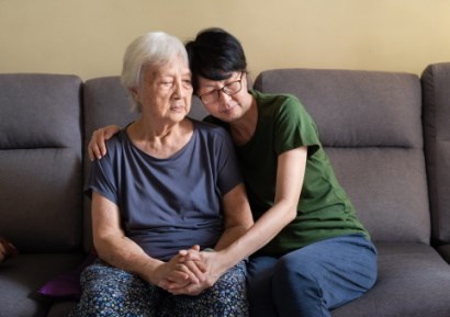 Elderly woman comforted by daughter