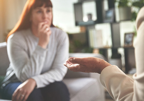 Someone talking to a worried woman