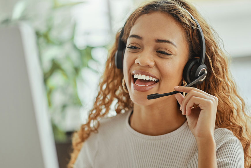 A happy woman taking a phone call using a headset