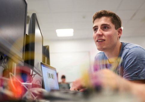 Man in jumper sitting at laptop