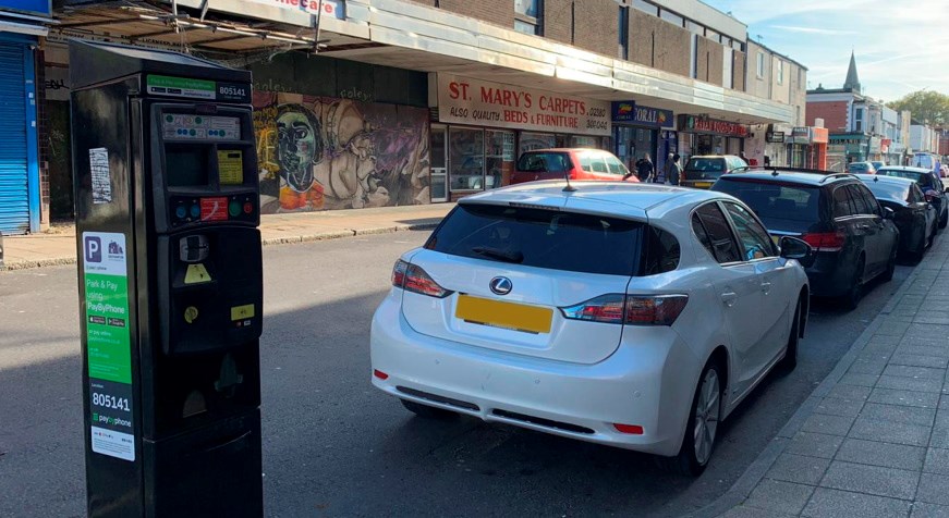 A parking meter and cars parked on a street