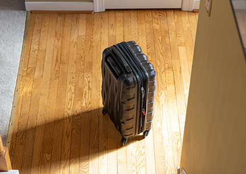 Suitcase facing the light of a door