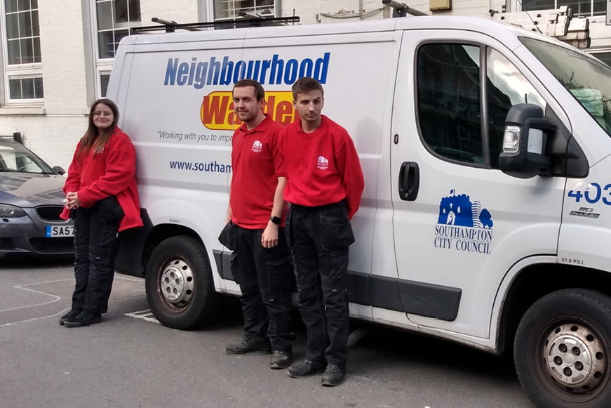 Three of the apprentices standing beside a Neighbourhood Warden van