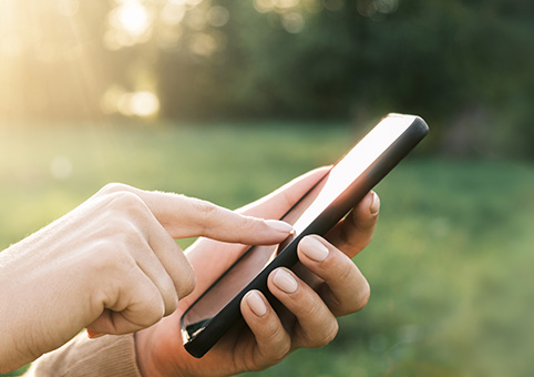 Someone typing on their phone outside
