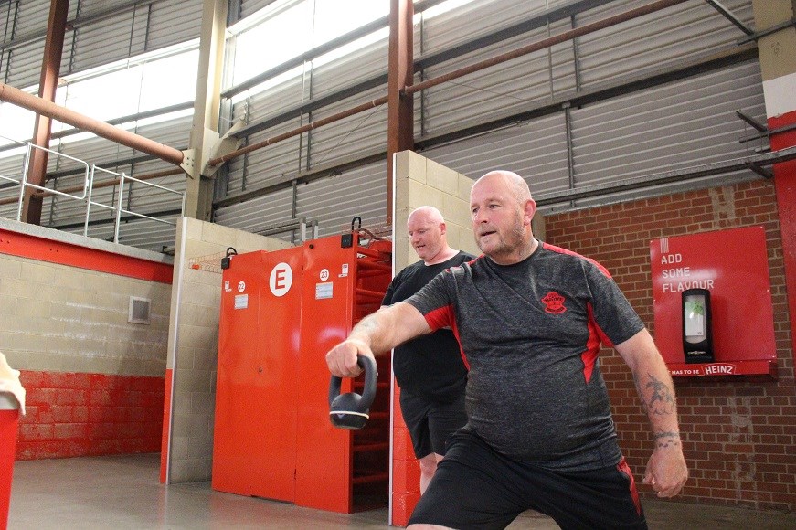 Man in exercise gear swinging kettle bell