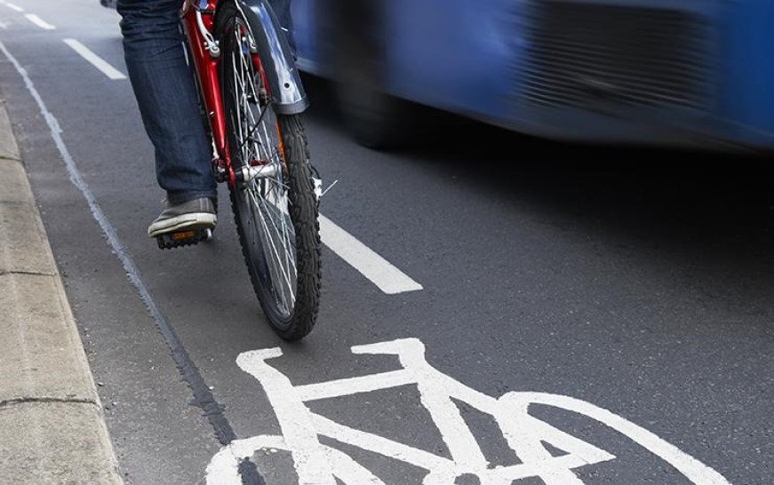 A bicycle in a bike lane alongside a bus