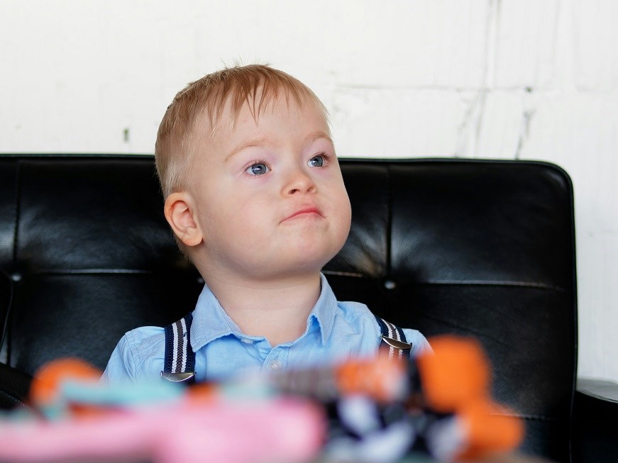 Young boy sitting on black chair