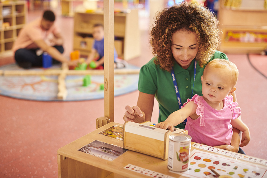 A woman holding a child at a day care centre