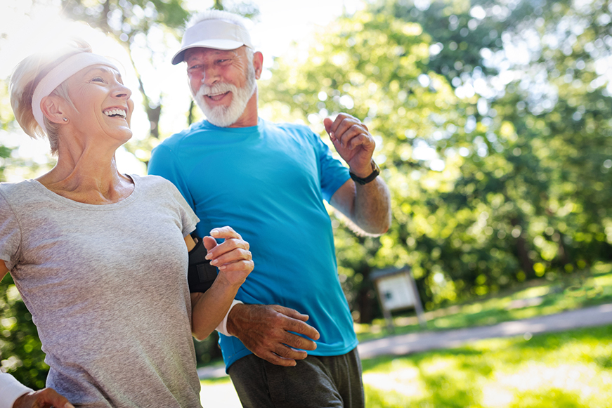 Older Pair Out Running In A Park